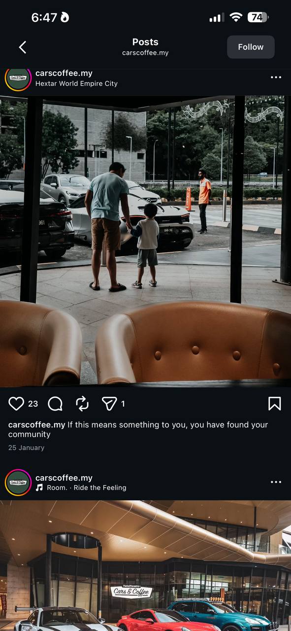 Leather armchairs looking out at a row of supercars parked in Empire City